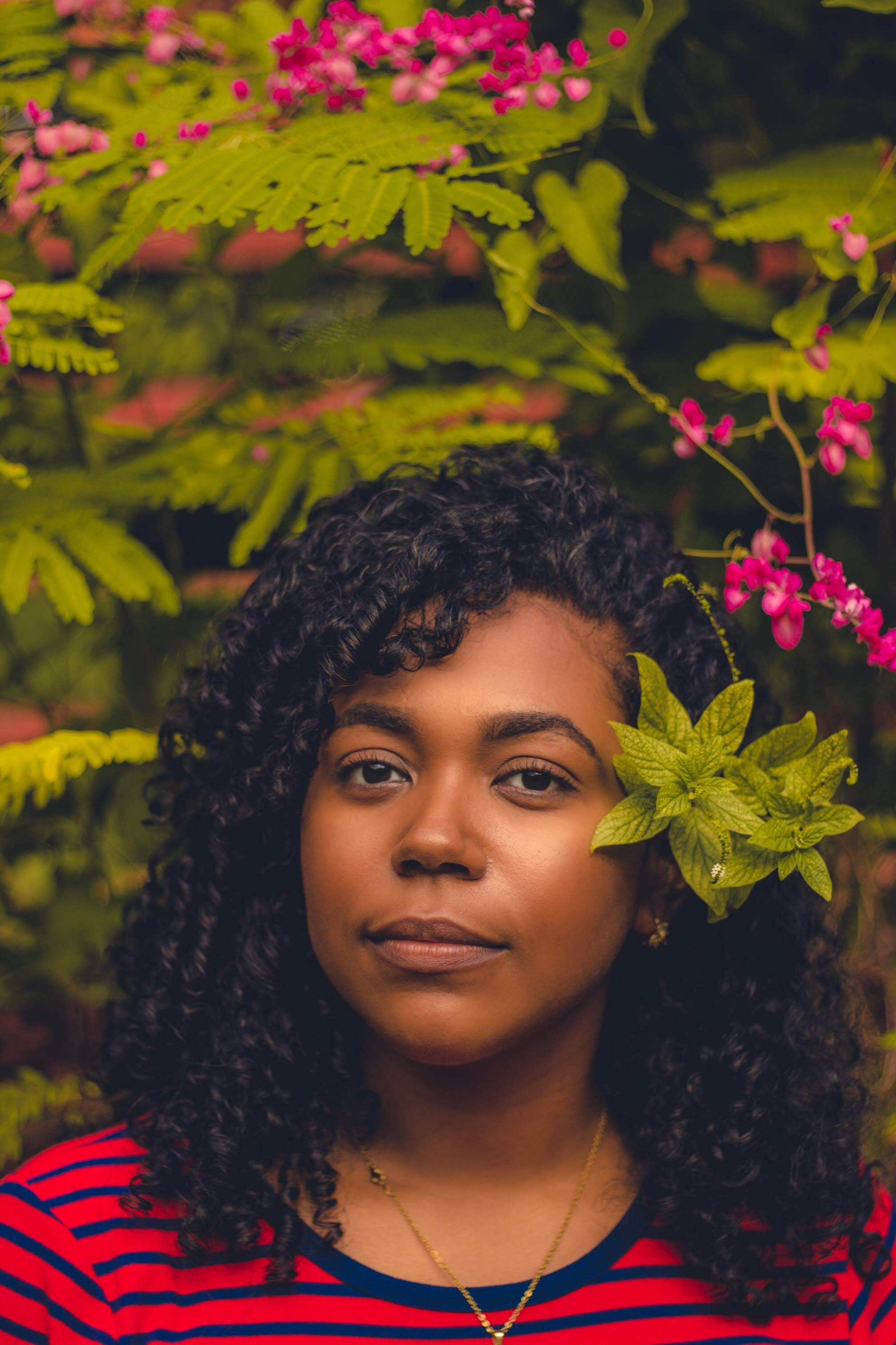 Portrait of Rocecil Rodríguez among tropical flowers